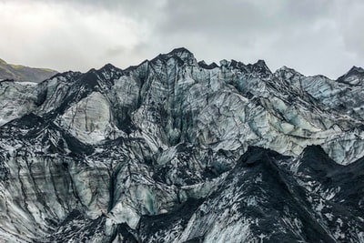 白天多云天空下的灰色落基山
